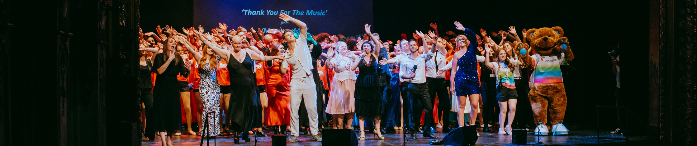 Performers waving on stage at the Lyceum Theatre during a finale