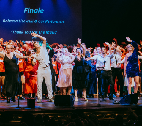 Performers waving on stage at the Lyceum Theatre during a finale